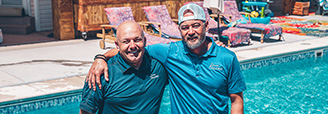 two men standing in front of a pool